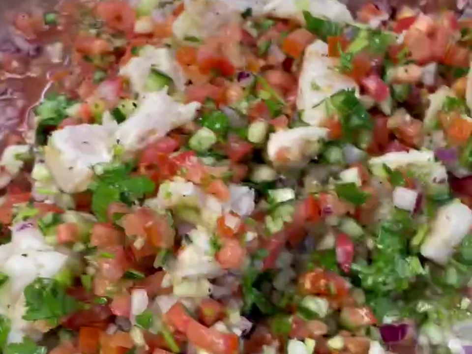 Fresh fish ceviche with tomato, cucumber, red onion, cilantro, and citrus