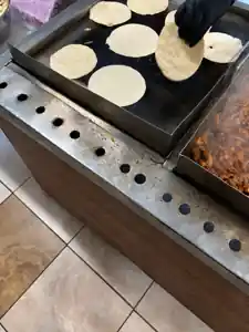 Fresh tortillas cooking on the grill at Delicias Daniel Catering